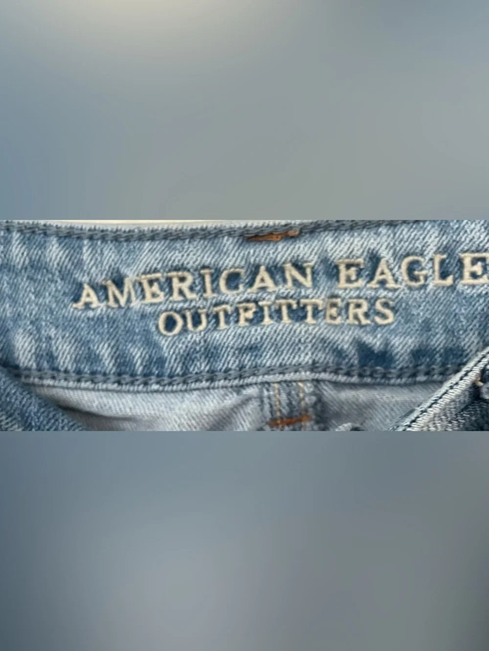 American Eagle women’s mid rise mid wash distressed hem cut off denim shorts; 10